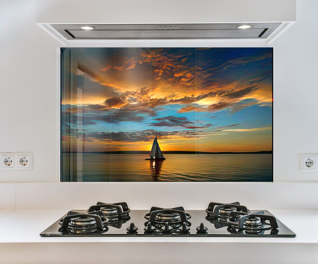 a picture of a sailboat on the water at sunset