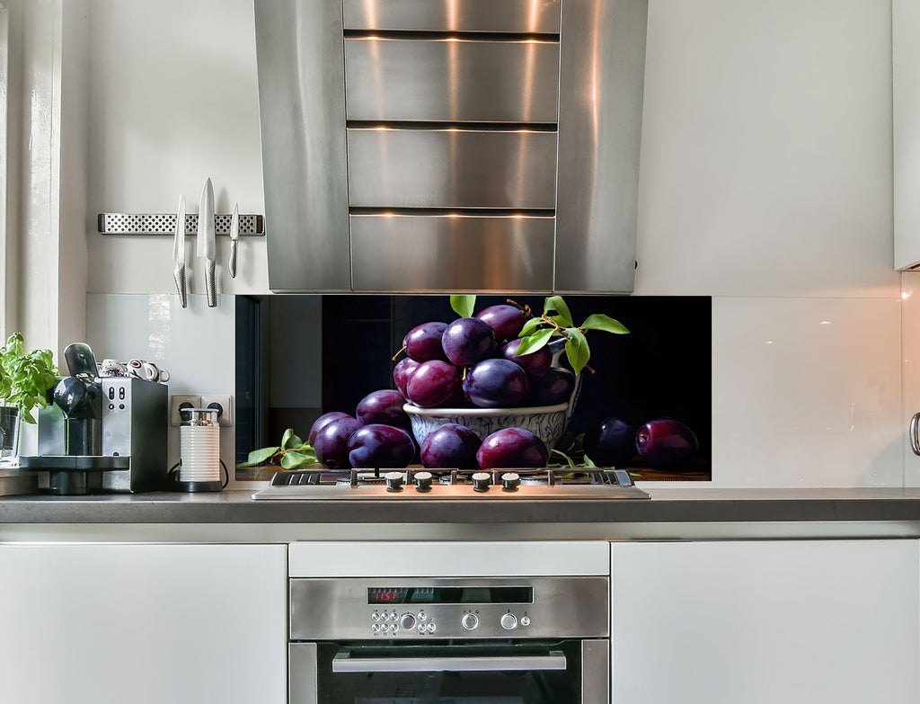 a picture of a bowl of plums on a kitchen counter