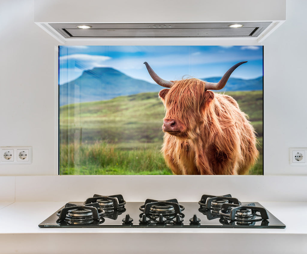 a picture of a cow is on the wall behind the stove