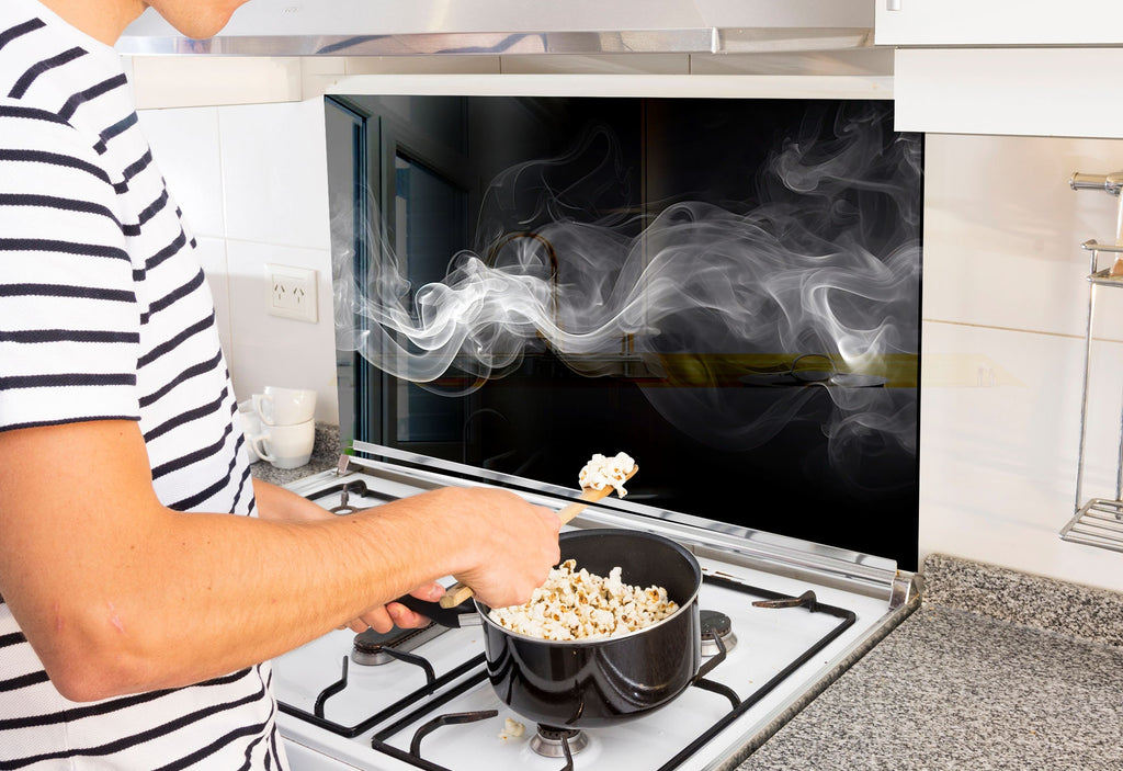 a man is cooking popcorn on the stove