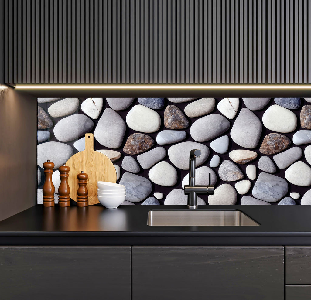 a kitchen with a black counter top and a stone wall behind it