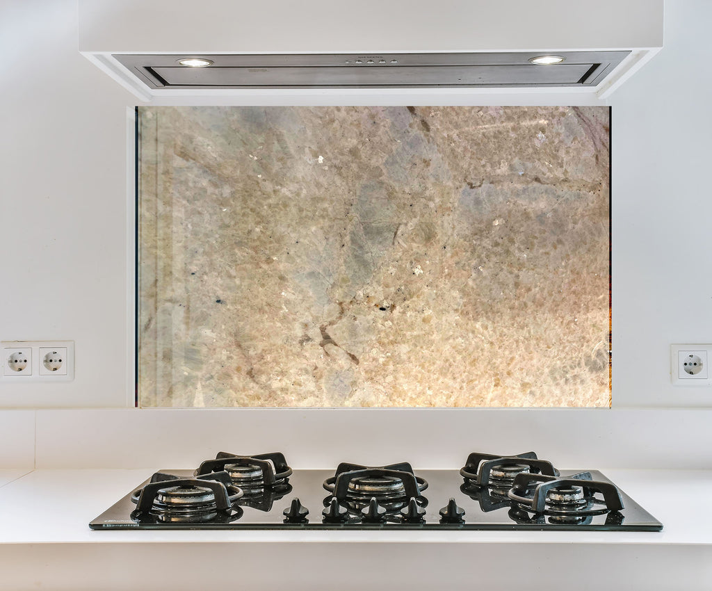 a stove top sitting under a window in a kitchen