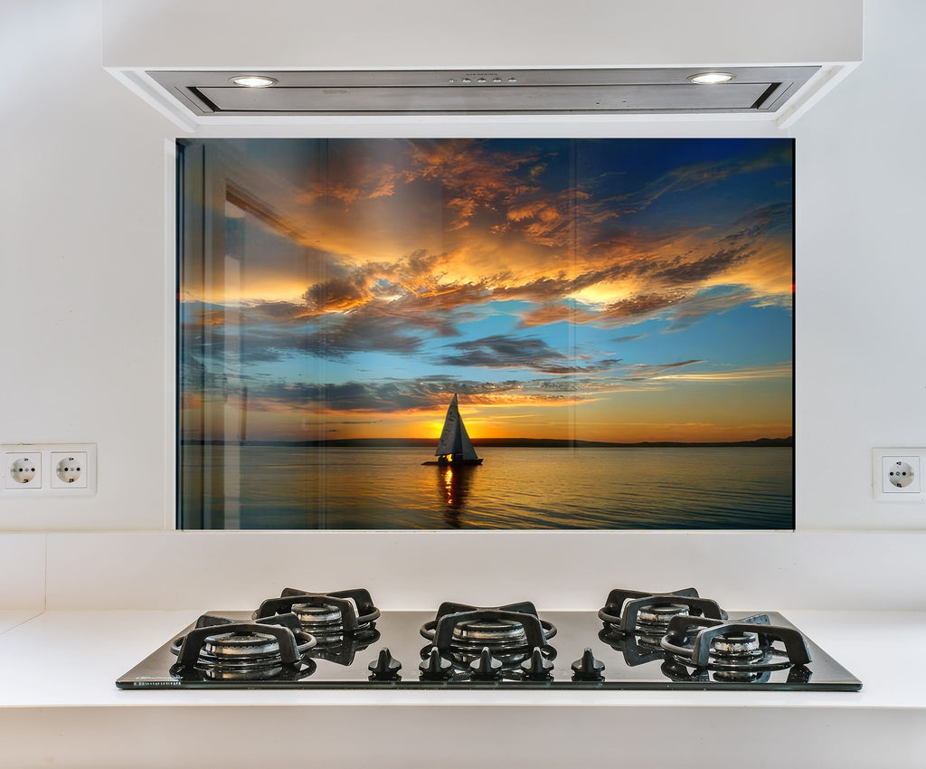 a picture of a sailboat on the water at sunset